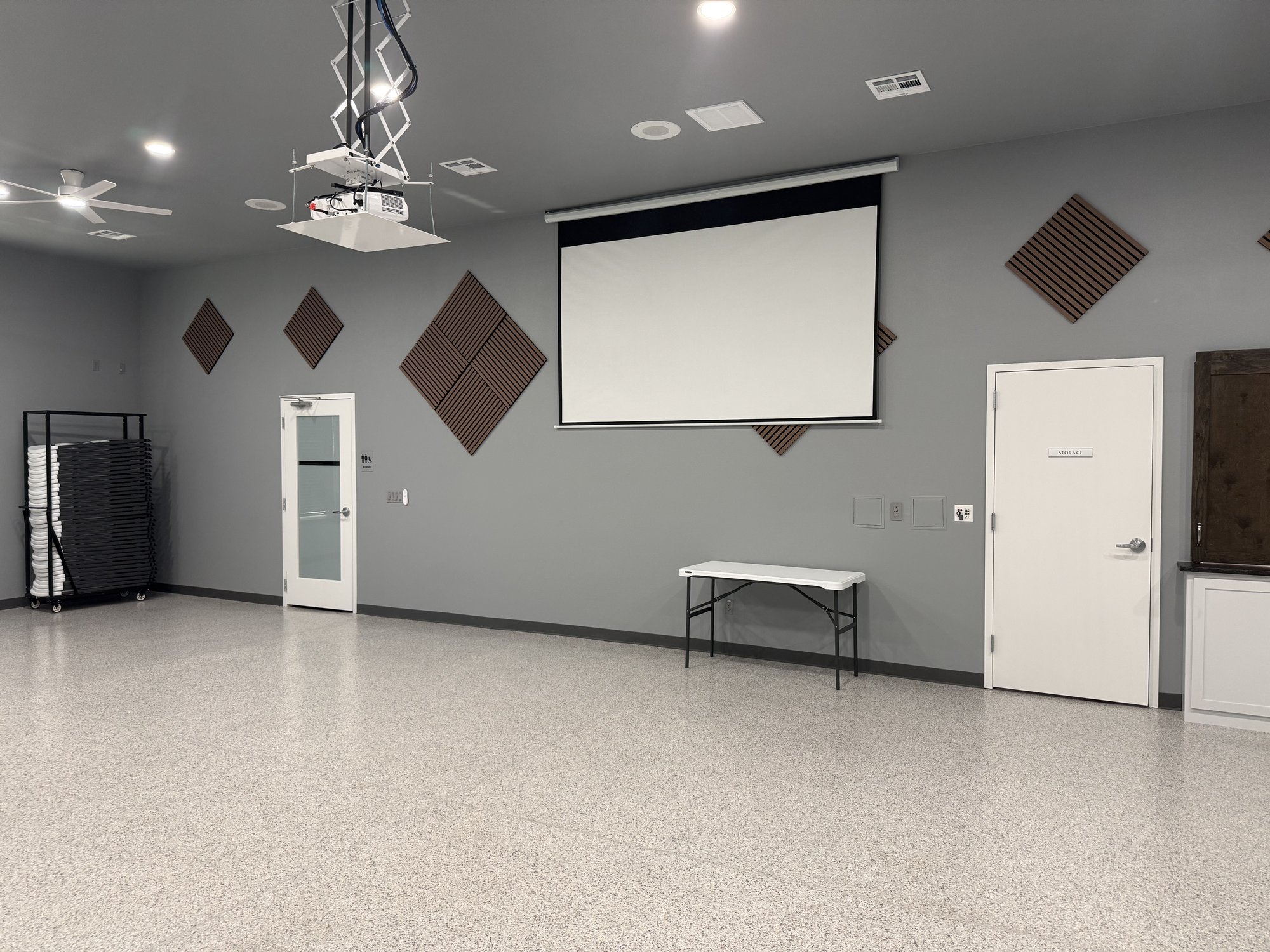 Projector screen and ceiling-mounted projector lift in the Community Center