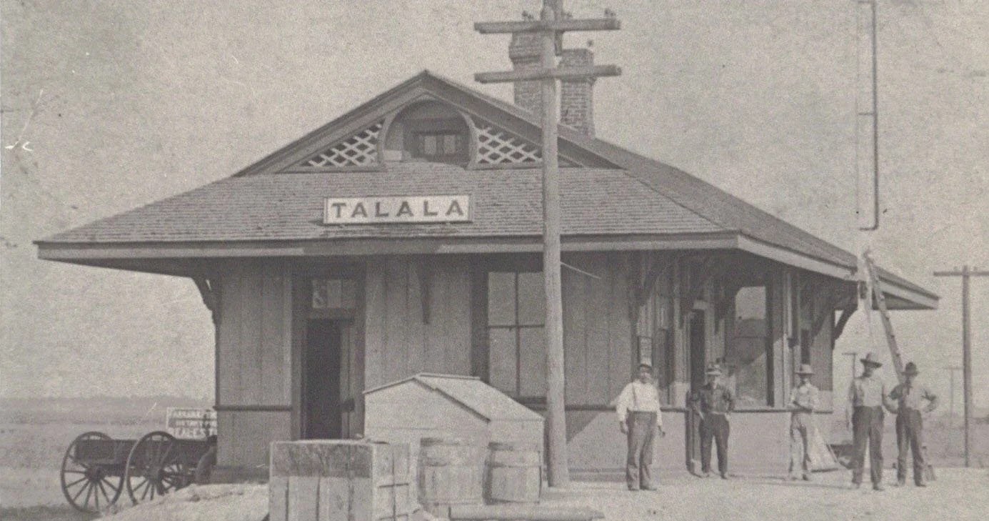 Early Talala depot with wagon, crates, and townspeople