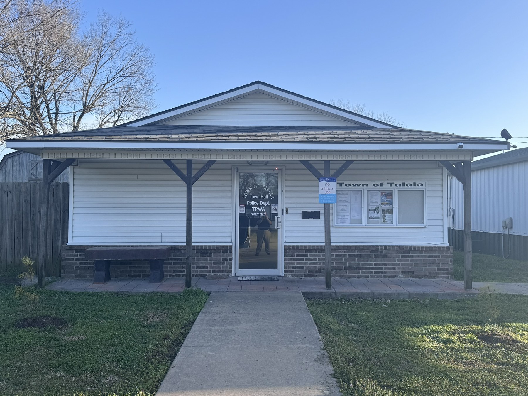 Former Talala Town Hall front porch and door on Watova Street, white siding and brick, before the expansion